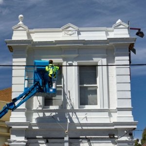 Our qualified melbourne painters working in exterior windows through a boom lift