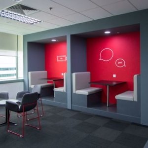 Work space for 2 with red wall and desk in the center
