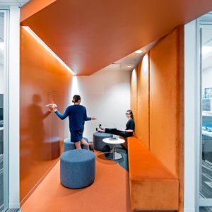 Meeting are with orange walls, orange carpet and coffee table